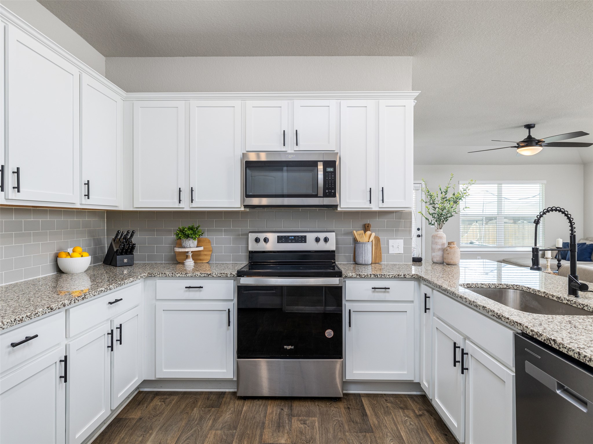 439 Hunter Loop Bertram, TX 78605 - Photo 9 of 23 Bright white cabinetry and granite counters define this inviting and functional kitchen.