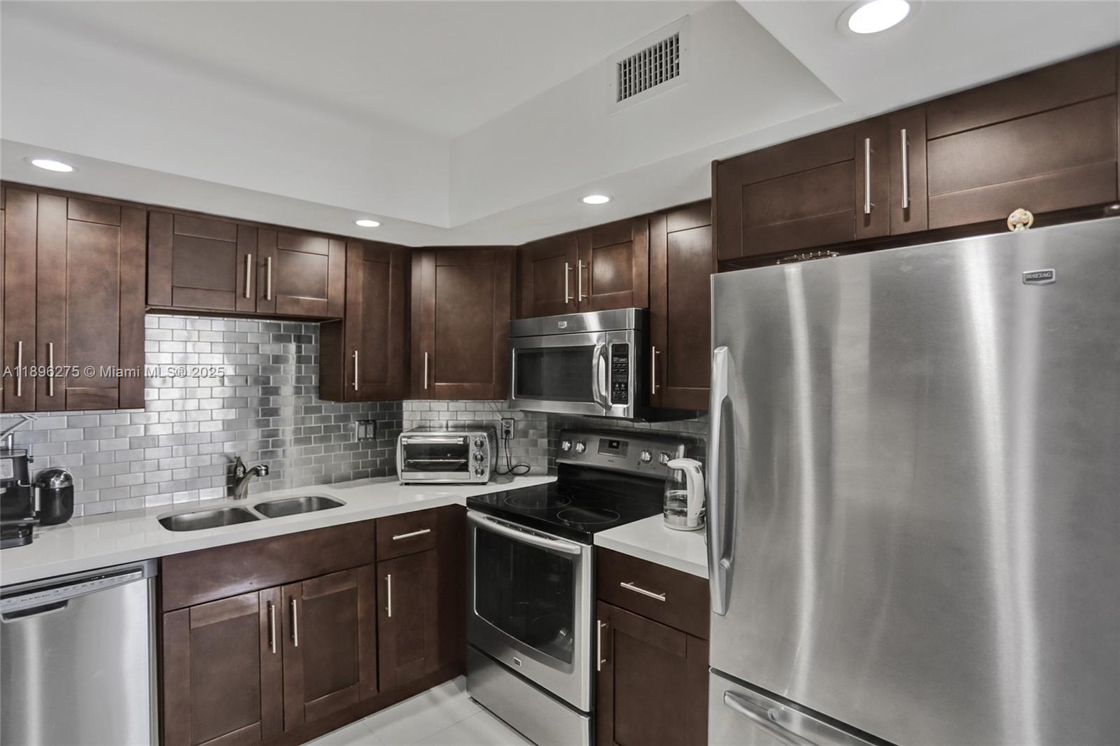 500 Bayview Drive, Unit 731 Sunny Isles Beach, FL 33160 - Photo 12 of 46 a kitchen with a refrigerator sink and microwave