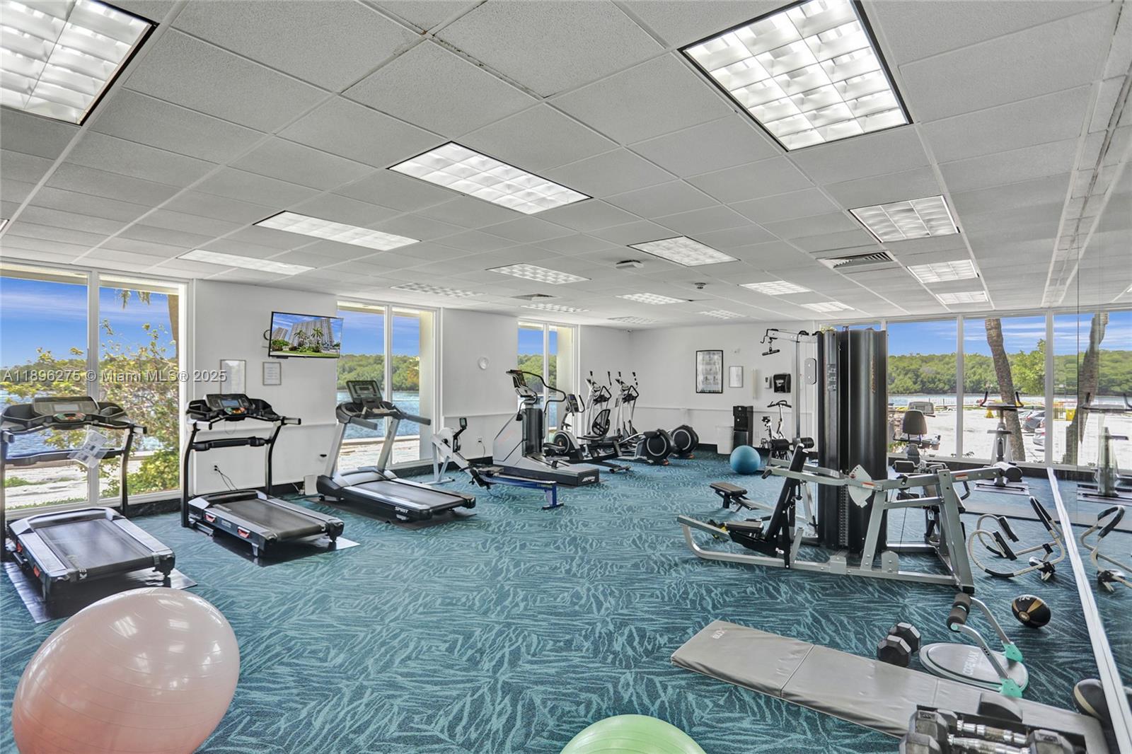 500 Bayview Drive, Unit 731 Sunny Isles Beach, FL 33160 - Photo 28 of 46 a living room with furniture gym equipment and large windows