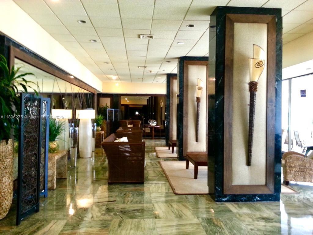 500 Bayview Drive, Unit 731 Sunny Isles Beach, FL 33160 - Photo 41 of 46 a hallway with a couch a dining table and chairs