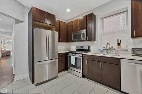 a kitchen with stainless steel appliances granite countertop a refrigerator and a sink