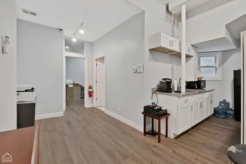 a kitchen with stainless steel appliances a kitchen island hardwood floor a sink and a refrigerator
