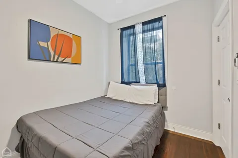 a bedroom with a bed and a painting on the wall