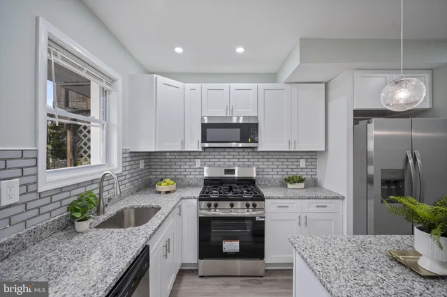 a kitchen with a stove a sink and a microwave