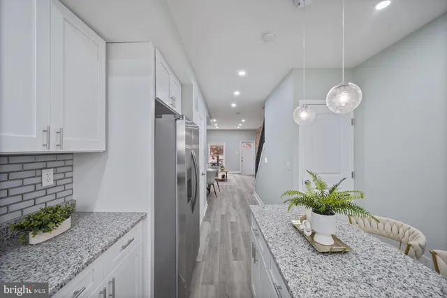 a kitchen with stainless steel appliances granite countertop wooden cabinets granite counter tops and a hard wood floors