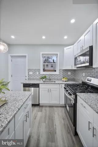 a kitchen with stainless steel appliances kitchen island granite countertop a sink and cabinets