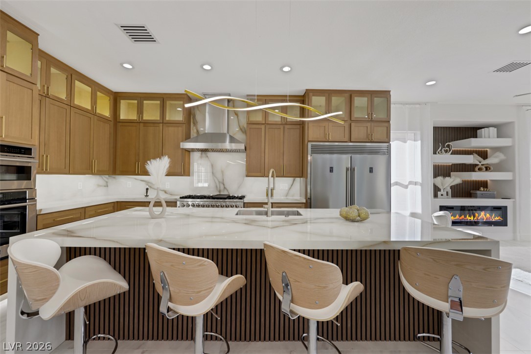 5015 Rivedro Street Las Vegas, NV 89135 - Photo 38 of 91 A well-appointed kitchen features a spacious island with ample seating, integrated appliances, and elegant cabinetry.