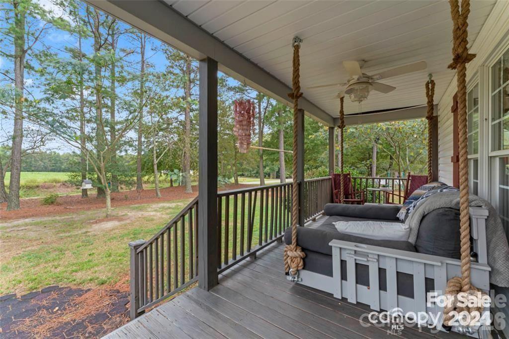 a view of a porch with furniture and a yard