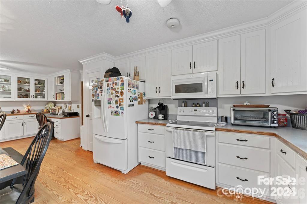 10560 Lake Royalle Road Spring Hope, NC 27882 - Photo 11 of 37 a kitchen with white cabinets and white appliances