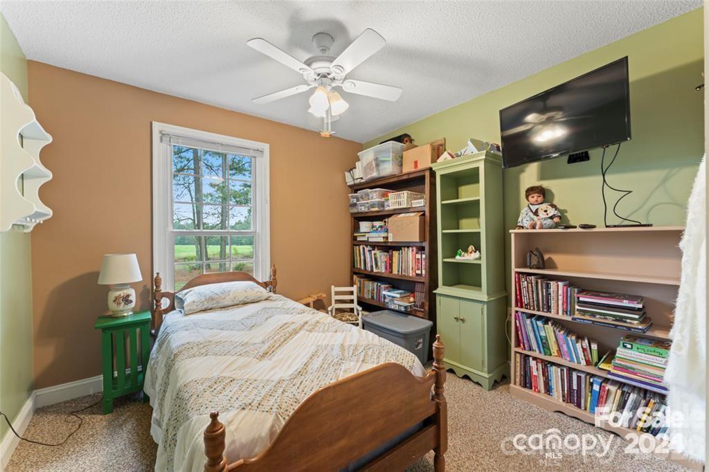 10560 Lake Royalle Road Spring Hope, NC 27882 - Photo 18 of 37 a bedroom with a bed a book shelf and a window