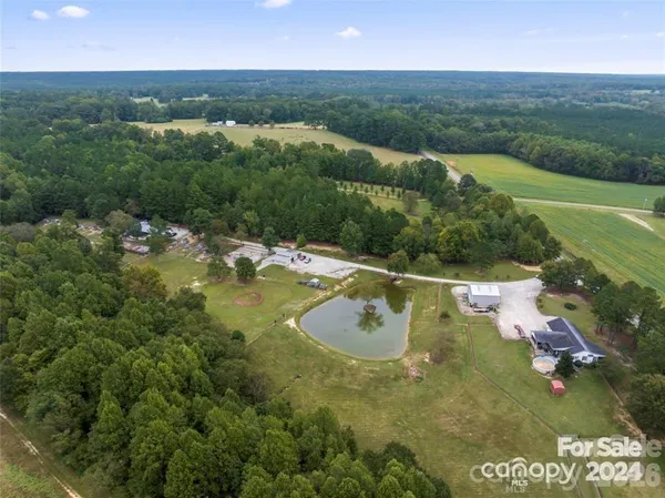 an aerial view of residential houses with outdoor space and trees