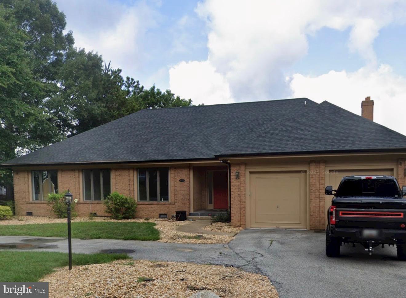 a front view of a house with a garden and parking space