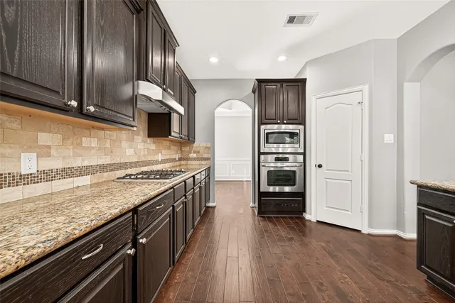a kitchen with stainless steel appliances granite countertop a stove and a refrigerator