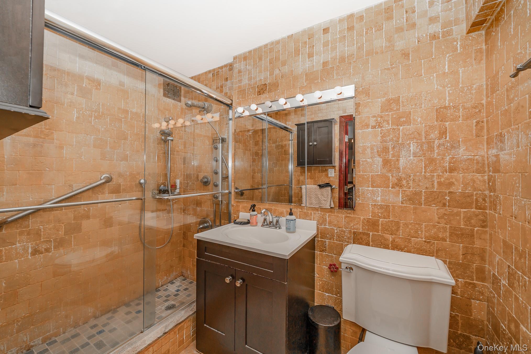 420 Shore Road, Unit 4C Long Beach, NY 11561 - Photo 12 of 41 a bathroom with a sink mirror and a shower