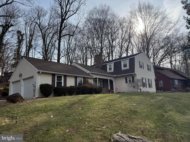 a view of a yard in front of a house with large windows
