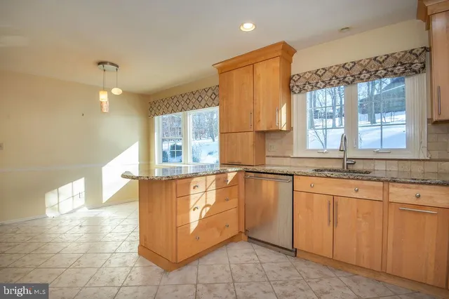 a view of a kitchen with granite countertop a sink and a window