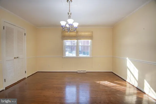 an empty room with wooden floor and window