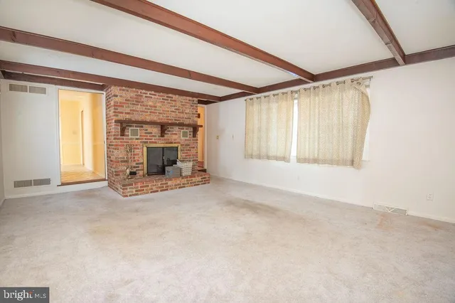 an empty room with fireplace and windows