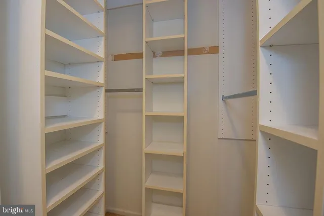 a view of walk in closet with empty racks