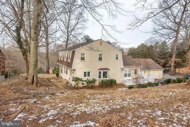 a front view of a house with a yard covered in snow