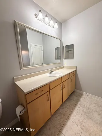a bathroom with a sink vanity and mirror