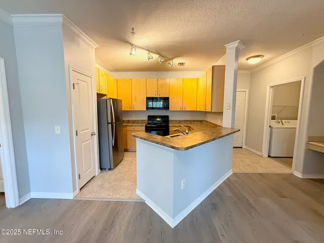 a kitchen with stainless steel appliances granite countertop a refrigerator a sink and a stove