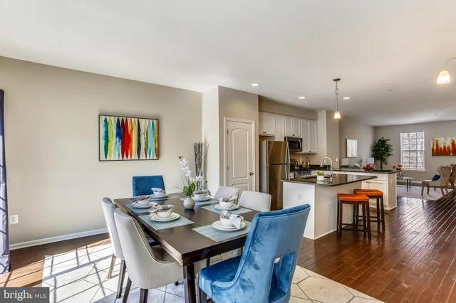 a dining room with wooden floor a chandelier a wooden table and chairs