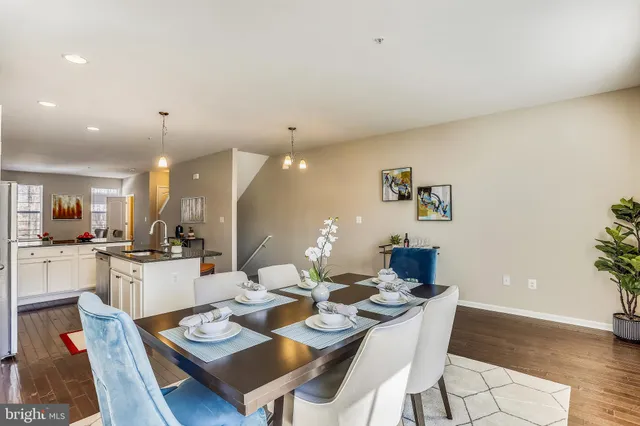 a dining room with wooden floor a chandelier a glass table and chairs
