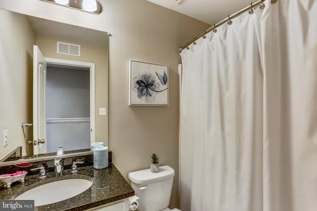 a bathroom with a sink vanity mirror and toilet