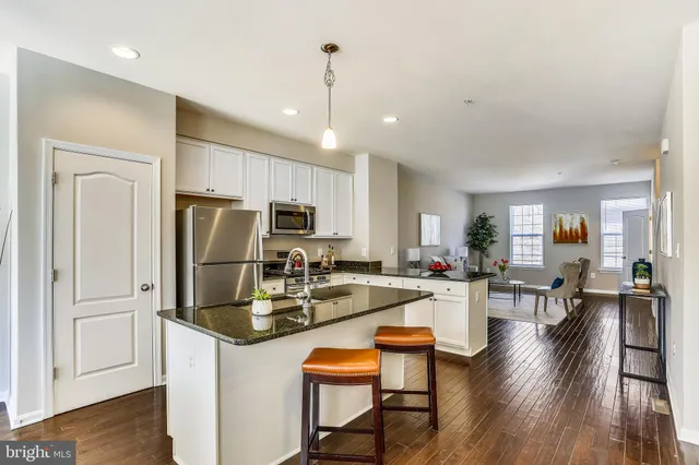 a kitchen with sink refrigerator dining table and chairs