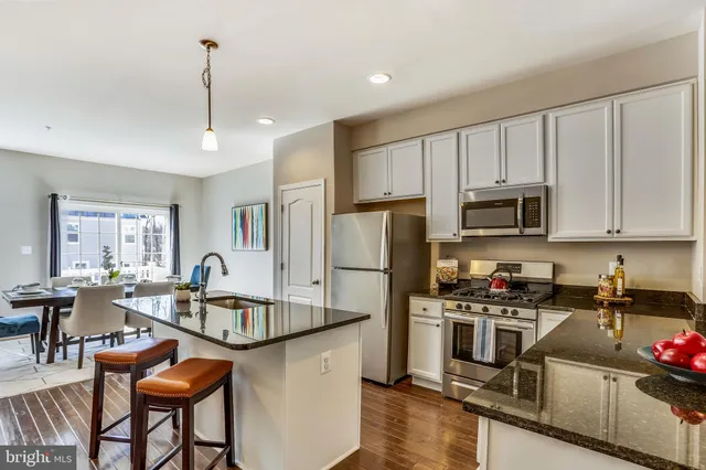 a kitchen with stainless steel appliances a stove a sink a microwave a refrigerator and cabinets