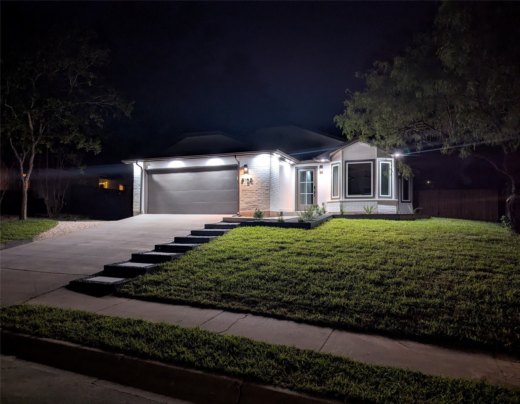 8102 Fort Sumter Road Austin, TX 78745 - Photo 1 of 28 Illuminated at dusk, a charming home presents a well-manicured lawn and a welcoming entryway.