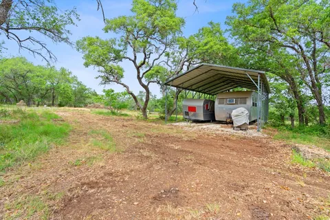 a view of backyard with table and chairs under an umbrella