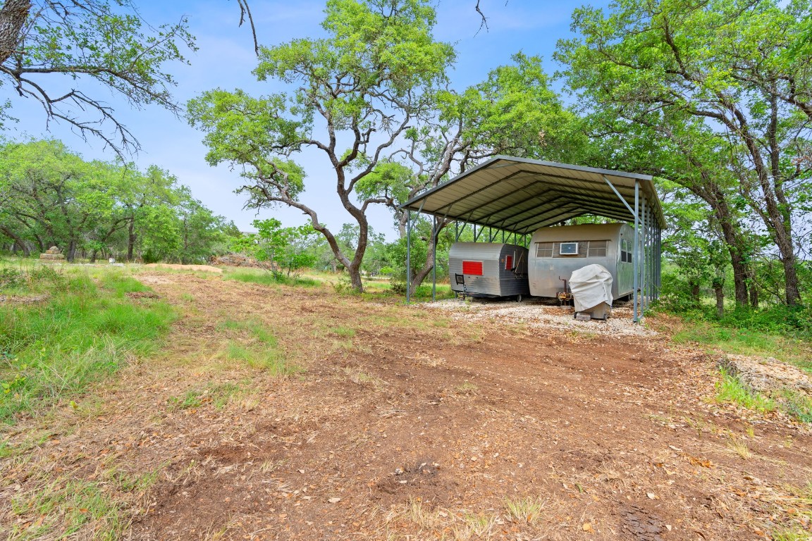 385 Country Lane Dripping Springs, TX 78620 - Photo 12 of 27 a view of backyard with table and chairs under an umbrella