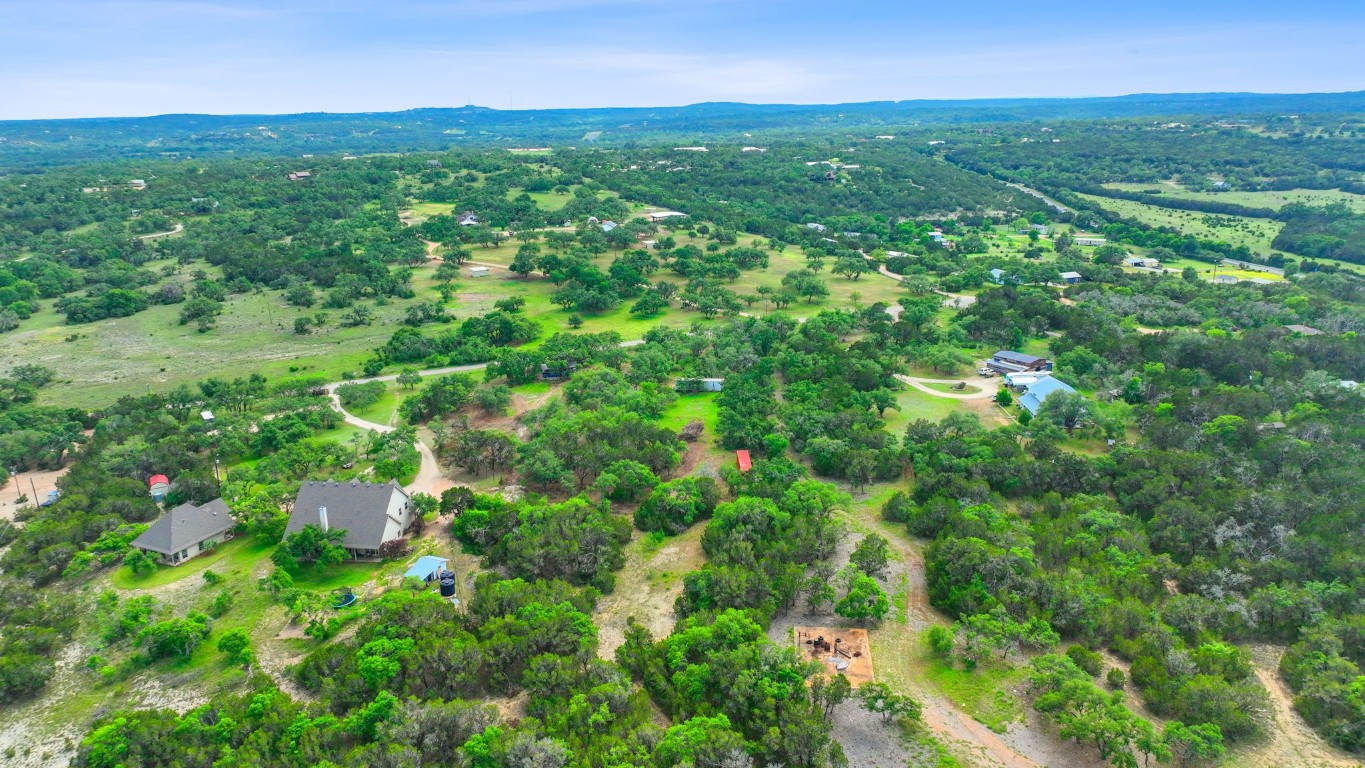 385 Country Lane Dripping Springs, TX 78620 - Photo 27 of 28 a view of a lush green field with a view of mountains in the background