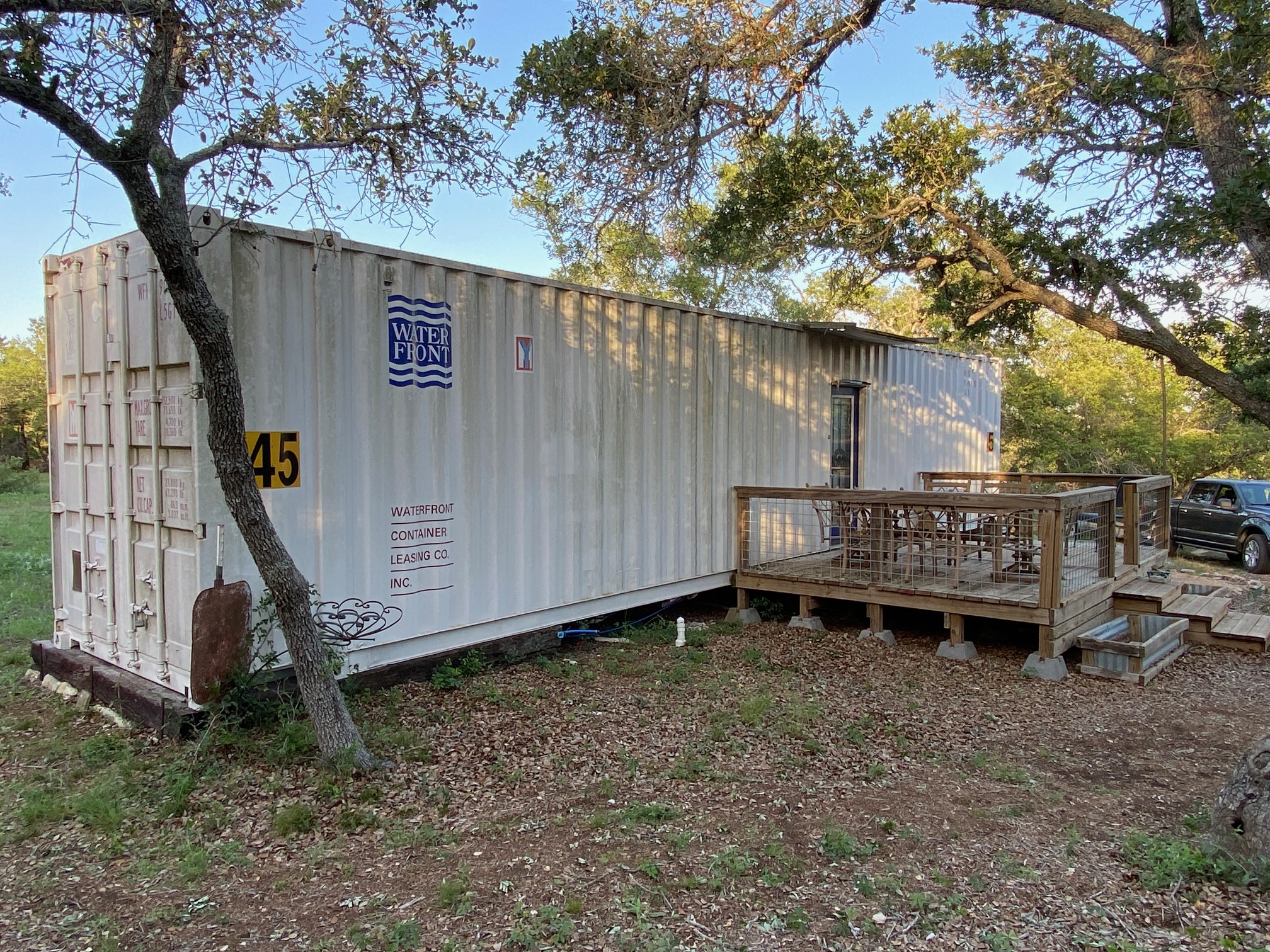 385 Country Lane Dripping Springs, TX 78620 - Photo 10 of 28 a backyard of a house with a bench and trees