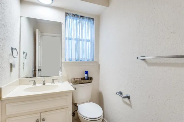 a bathroom with a sink toilet and a mirror