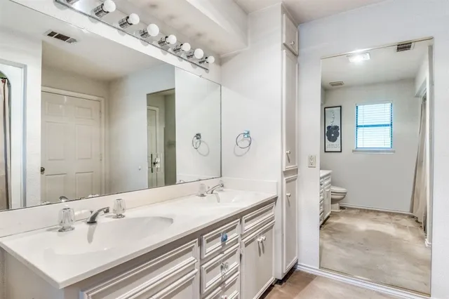 a en suite bathroom with a double vanity sink and a mirror