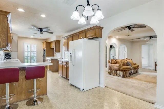 a kitchen with stainless steel appliances granite countertop a sink dishwasher a refrigerator with wooden floor