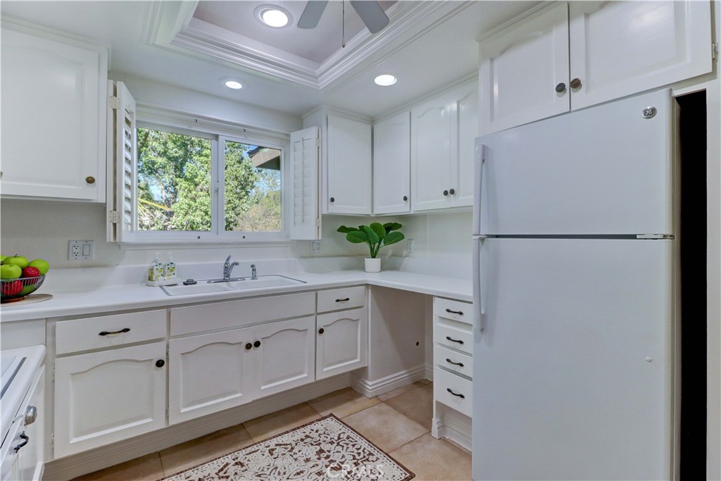 912 Ronda Sevilla, Unit O Laguna Woods, CA 92637 - Photo 19 of 55 a kitchen with cabinets appliances a sink and a window