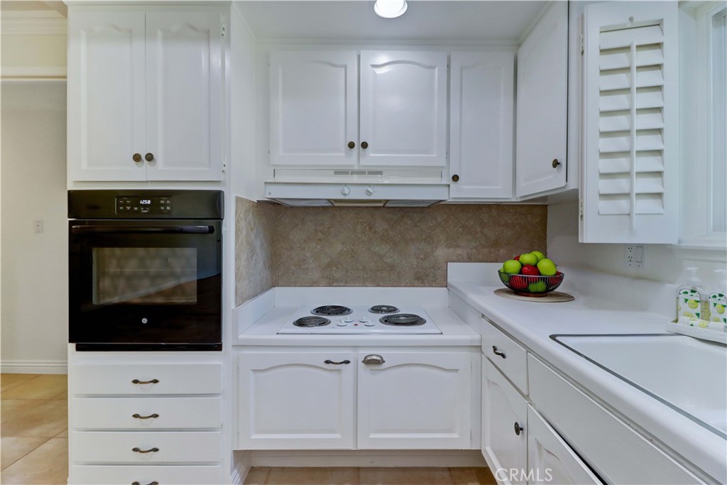 912 Ronda Sevilla, Unit O Laguna Woods, CA 92637 - Photo 20 of 55 a kitchen with white cabinets and appliances