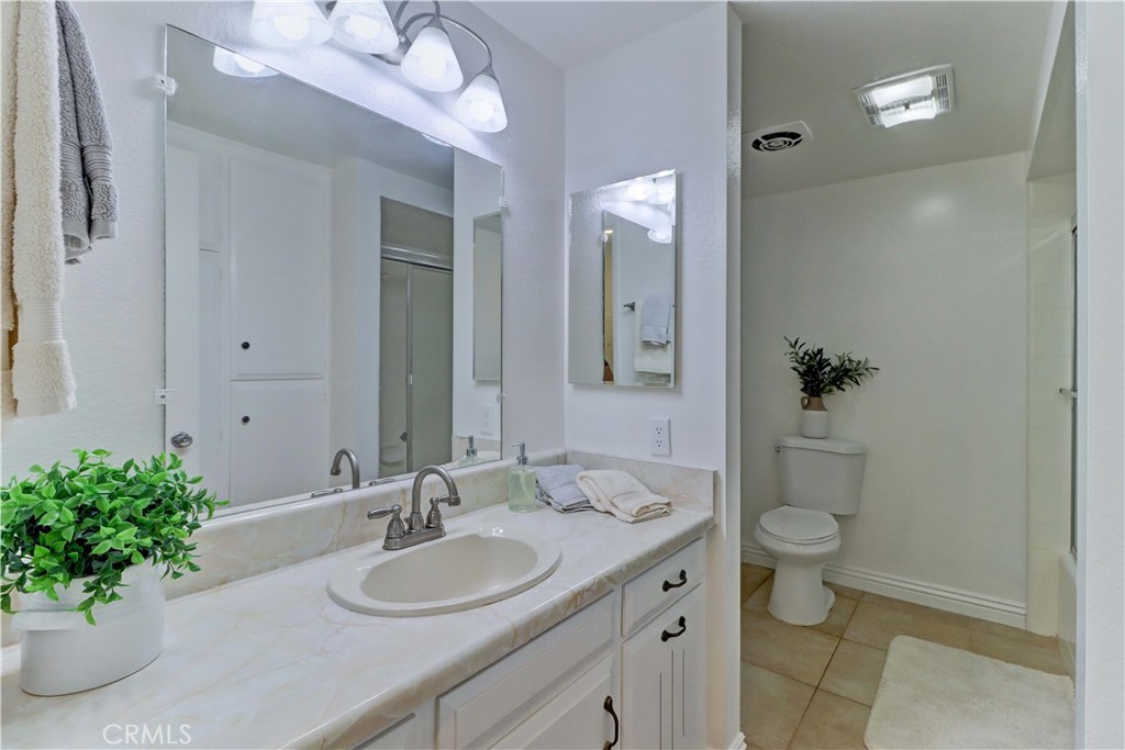 912 Ronda Sevilla, Unit O Laguna Woods, CA 92637 - Photo 27 of 55 a bathroom with a granite countertop sink a toilet and a mirror