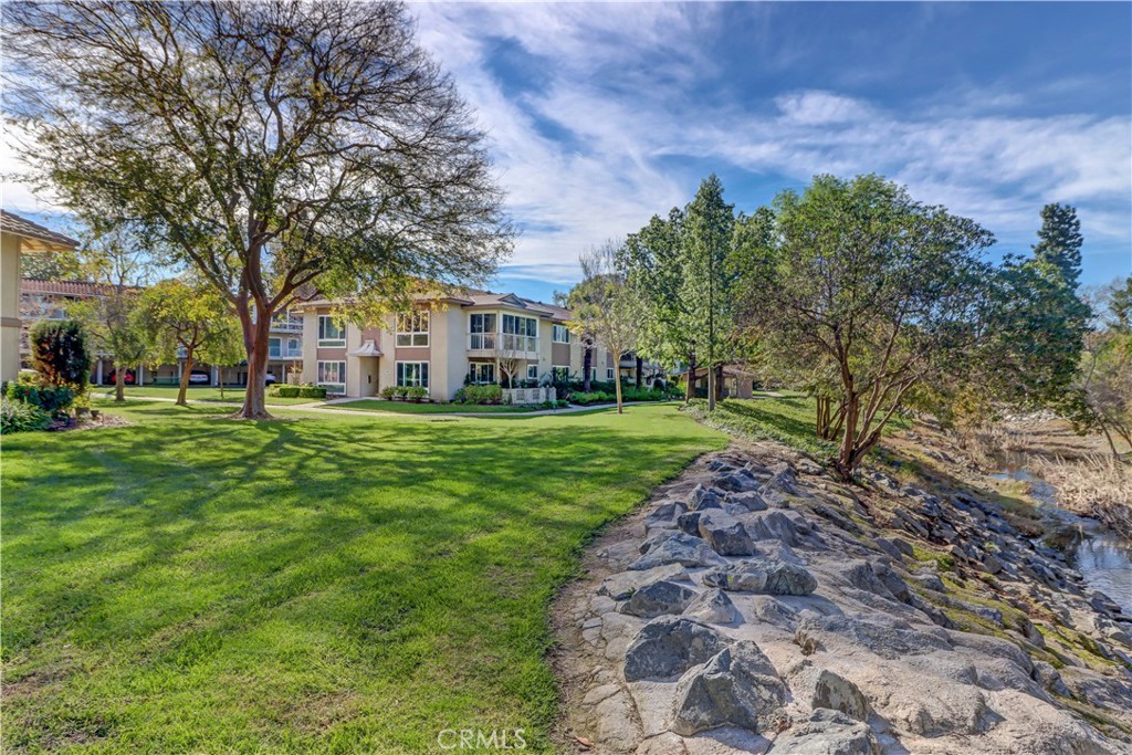 912 Ronda Sevilla, Unit O Laguna Woods, CA 92637 - Photo 33 of 55 a view of a house with a big yard and large trees