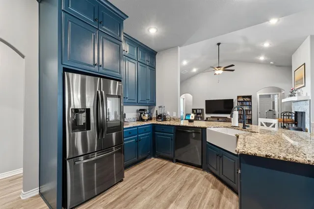a kitchen with stainless steel appliances granite countertop a refrigerator and a stove top oven