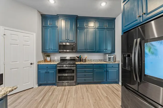 a large white kitchen with a large window and counter space