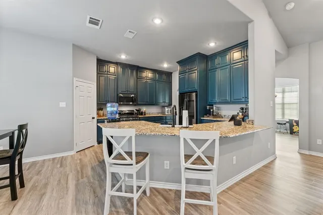 a spacious bedroom with a bed and a flat tv screen on the dresser