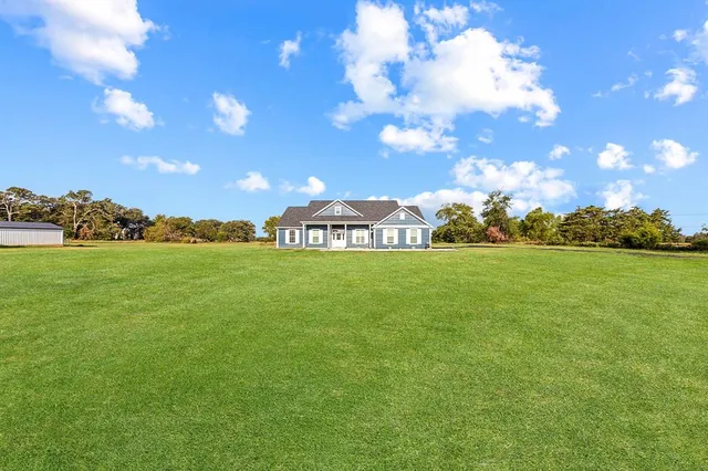 a view of a golf course with huge green field and building in the background