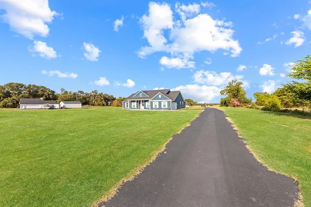 a view of a garden with a house in the background