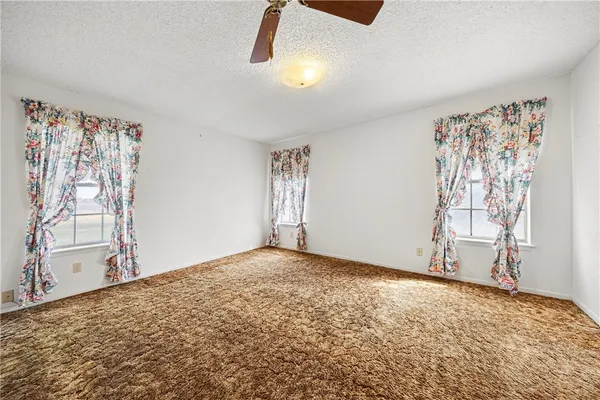a view of a big room with closet and a ceiling fan