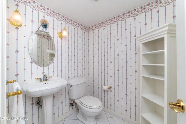 a bathroom with a sink a toilet and a mirror